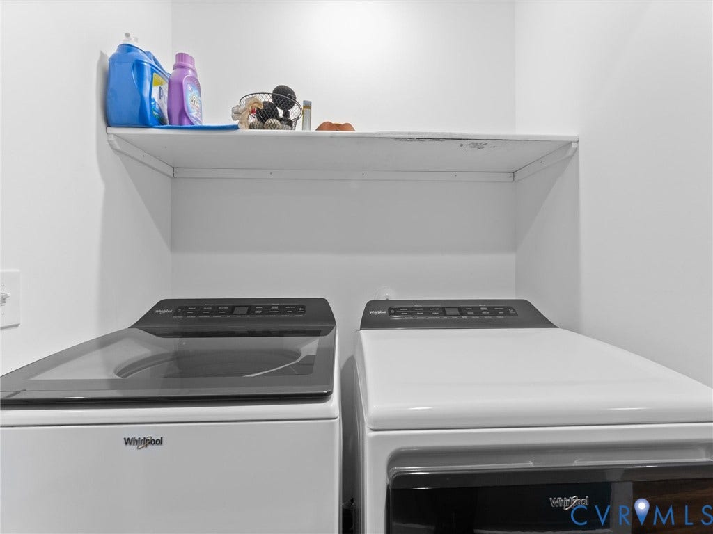 Built-in overhead shelving unit, white walls, and two Whirlpool appliances