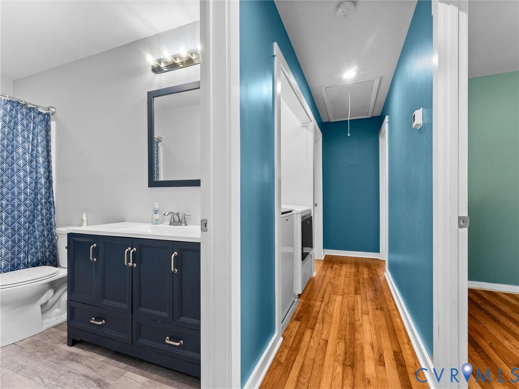 Bathroom featuring a vanity with dark blue cabinetry, a white countertop, and a rectangular mirror