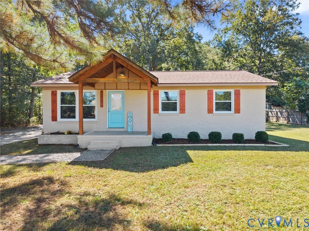 Light-toned exterior with a covered entry, wood-toned porch supports, and a distinct turquoise front door