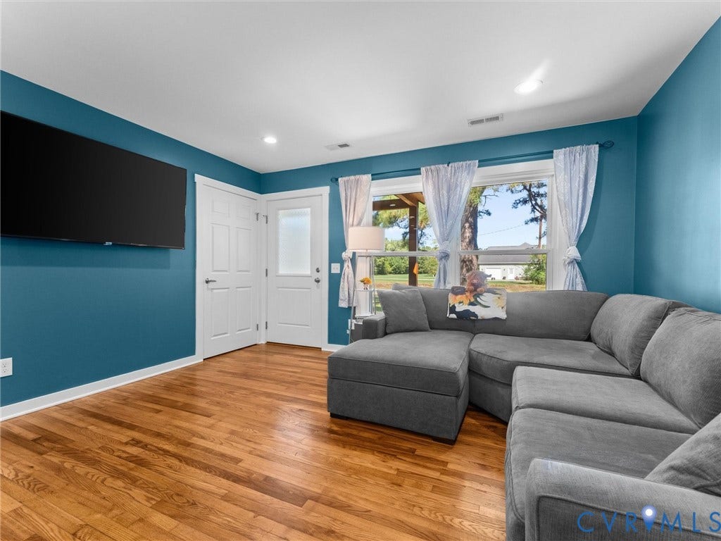 Hardwood flooring, recessed lighting, white trim, and a white paneled door with frosted glass insert