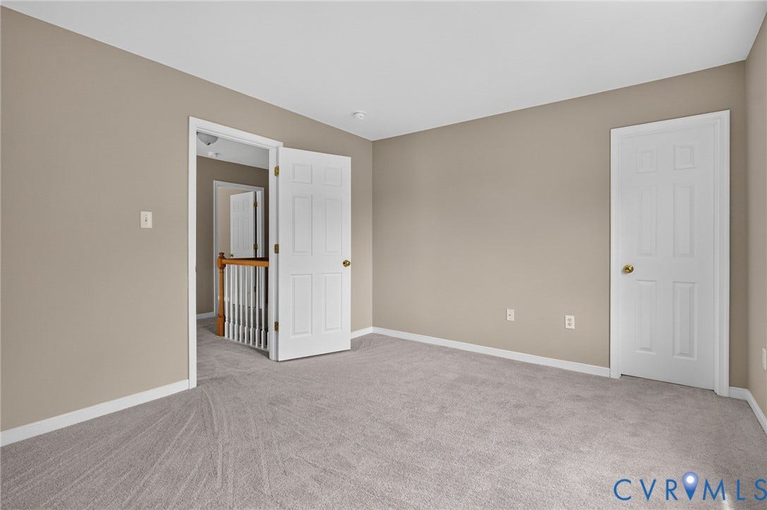 Neutral-toned walls complement plush carpeting