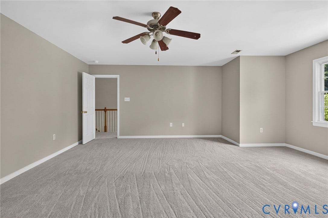 Neutral-toned walls complement the light gray carpet flooring