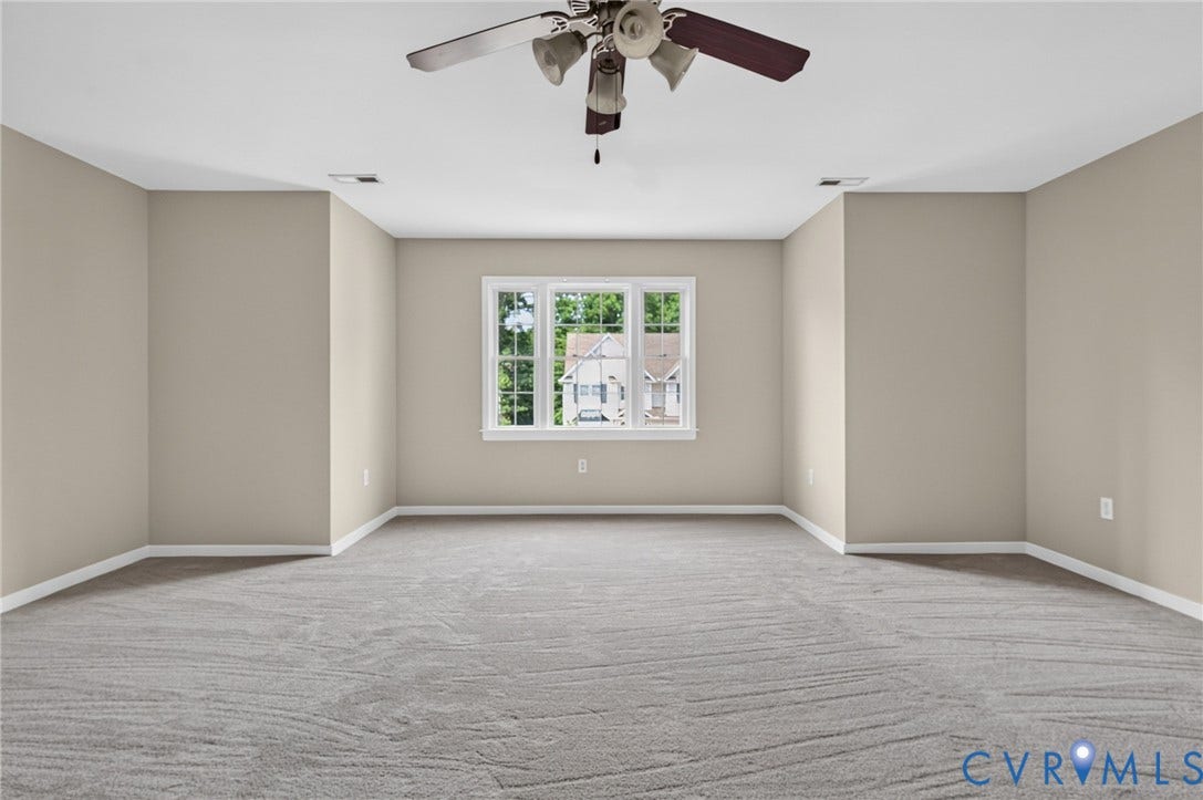 Neutral tone walls, ceiling fan, carpeted flooring, and white trim