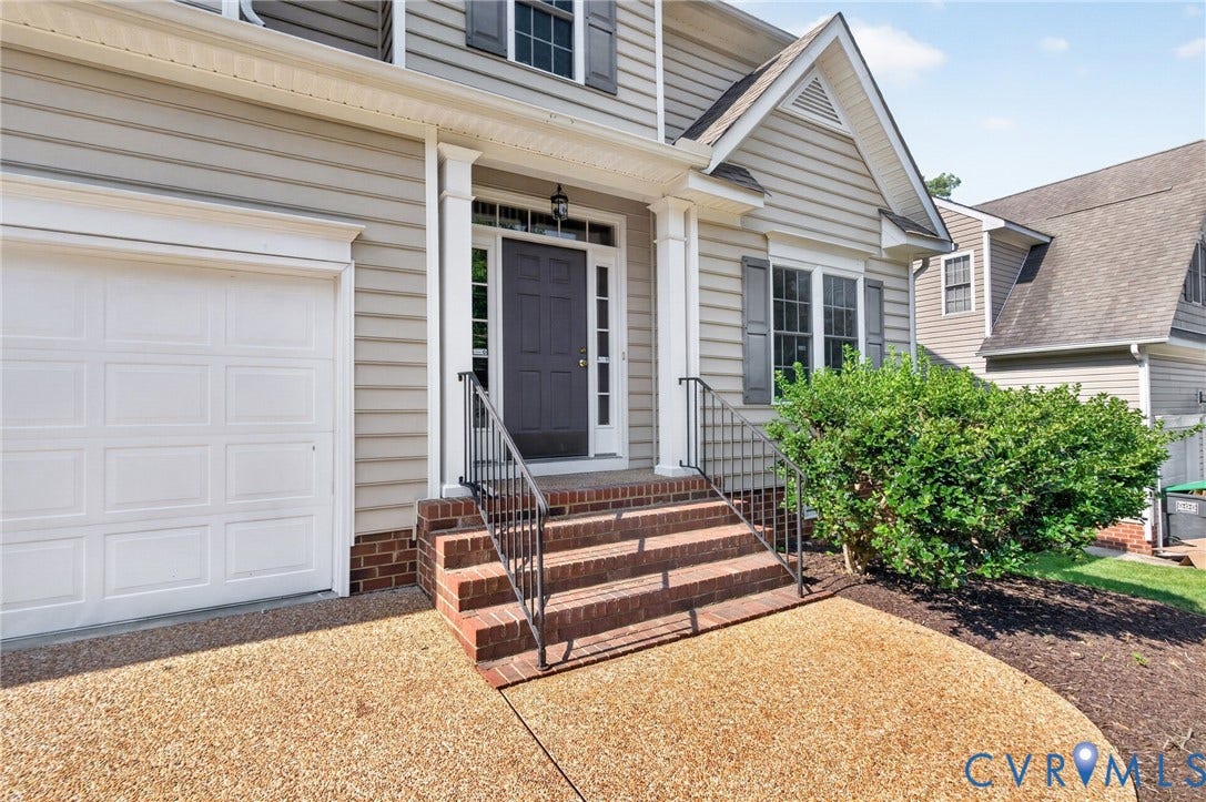 Siding exterior with brick foundation and portico entry