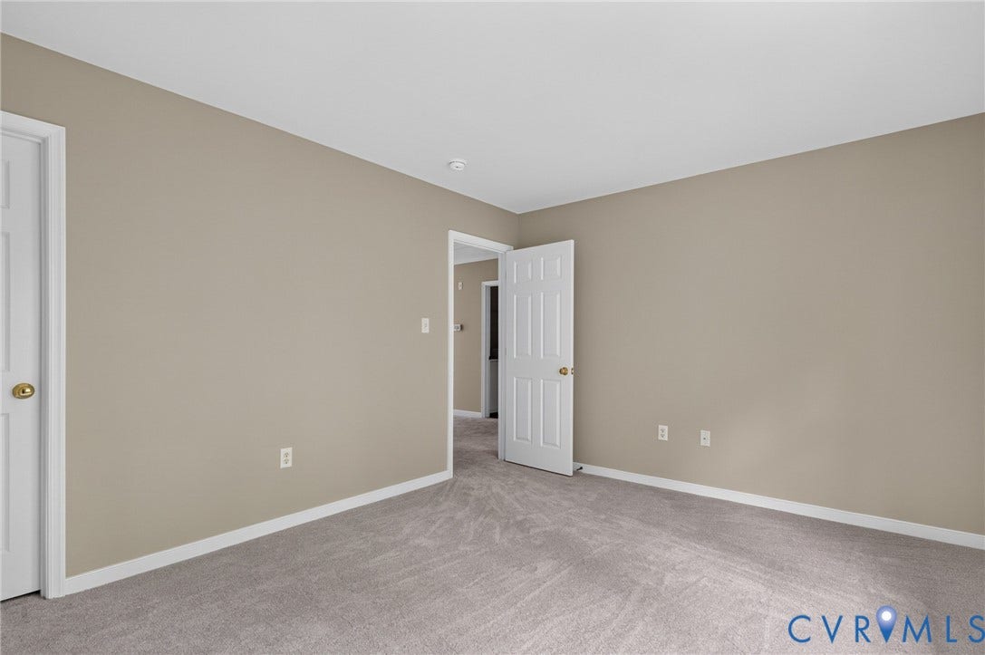 Wall-to-wall carpeting with neutral wall tones and white trim