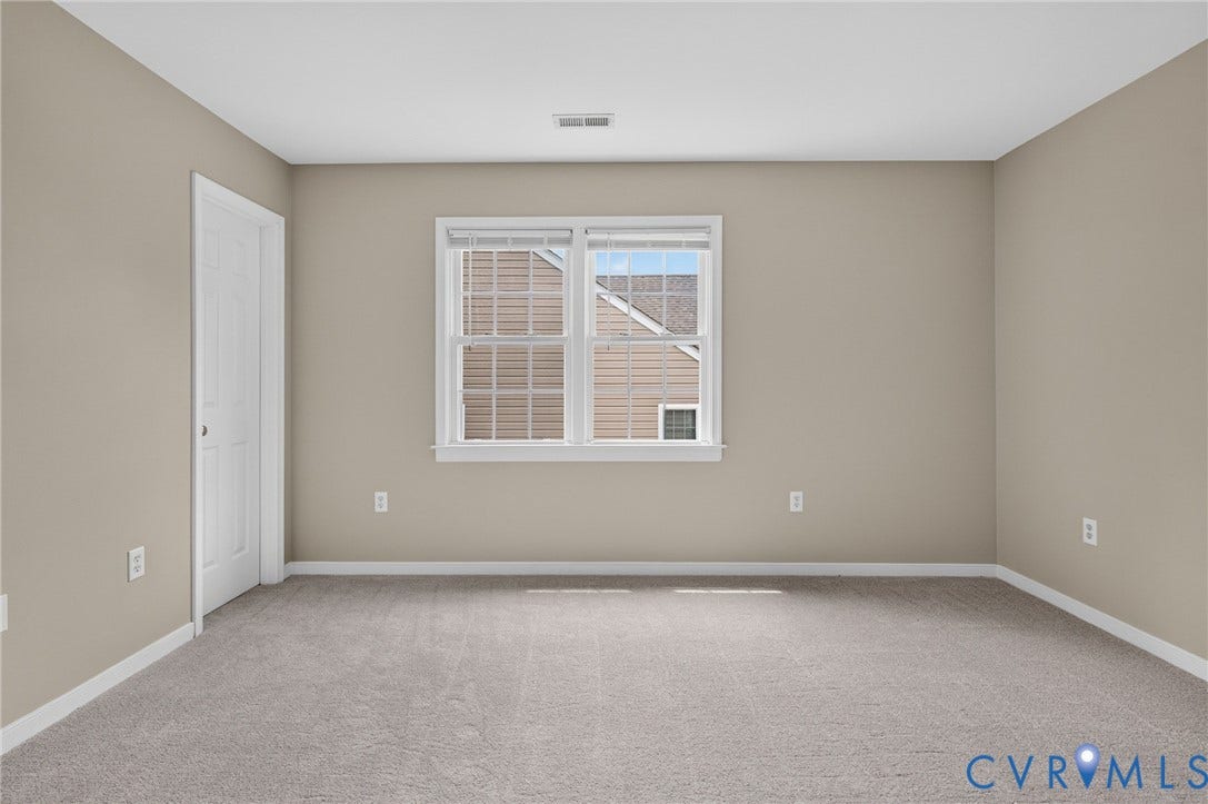 Neutral-toned walls and plush gray carpeting