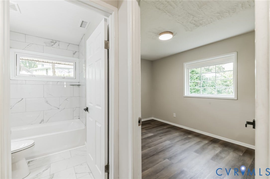 Bathroom with white subway tile shower surround and bathtub, complemented by a white toilet