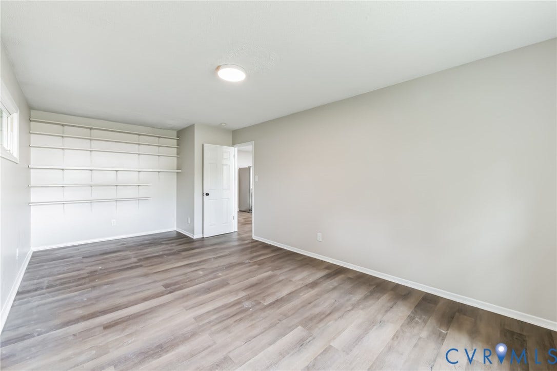 Neutral-toned walls, wood-finish flooring, built-in shelving, and recessed lighting