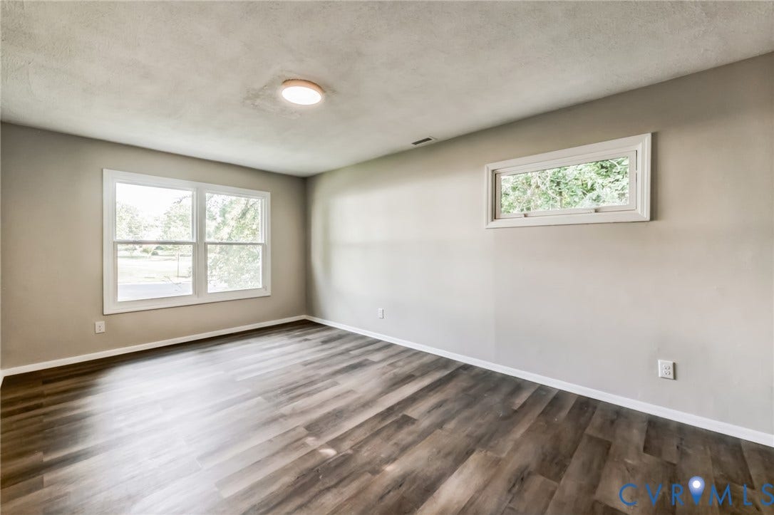 Wood-finish flooring, neutral wall tones, white trim, recessed lighting, and multiple windows