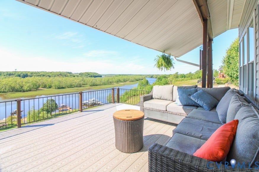 511 Riverview Court, Chester, VA 23836 Covered outdoor deck with composite decking, black metal railings, and natural wood posts