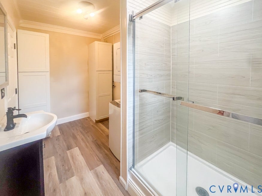 511 Riverview Court, Chester, VA 23836 Glass-enclosed shower with tile surround, wood-finish flooring, and white built-in cabinetry