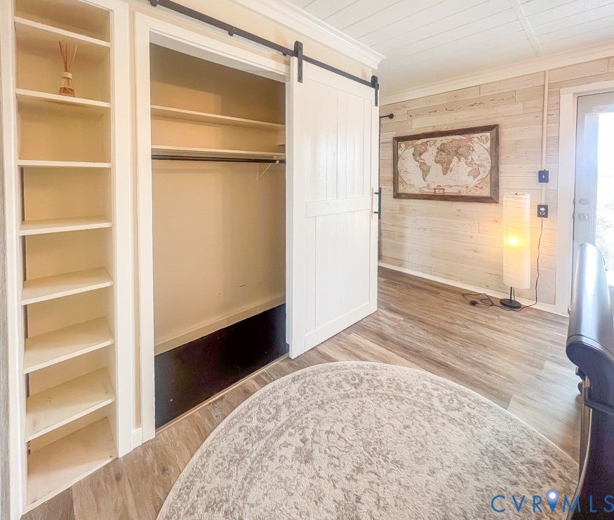 511 Riverview Court, Chester, VA 23836 Built-in shelving, barn door, wood-finish flooring, accent wall paneling, and a panel ceiling