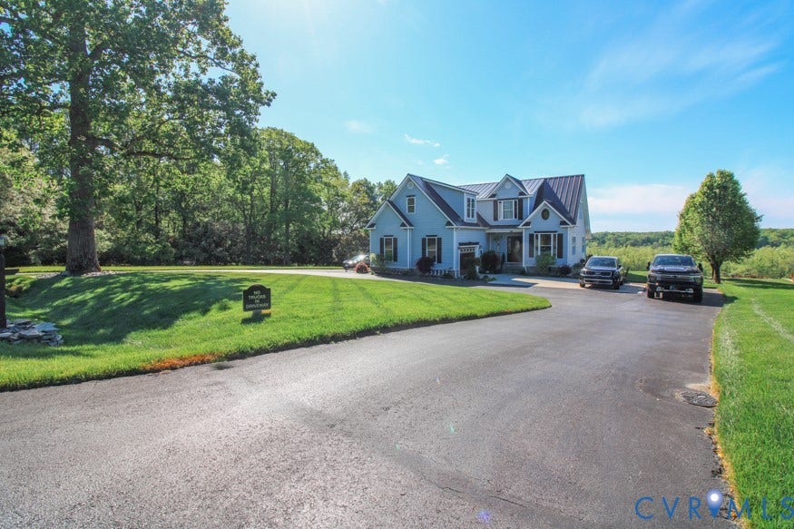 511 Riverview Court, Chester, VA 23836 Light blue siding exterior with dark shutters, multiple dormer windows, and a dark metal roof