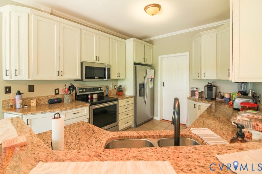 511 Riverview Court, Chester, VA 23836 Kitchen featuring a double basin stainless steel sink, black faucet, light-toned cabinetry with dark hardware, and a built-in microwave