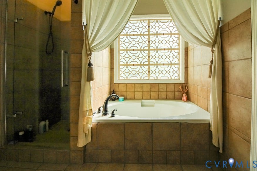 511 Riverview Court, Chester, VA 23836 Built-in soaking tub with decorative window, separate glass-enclosed shower, and tiled walls