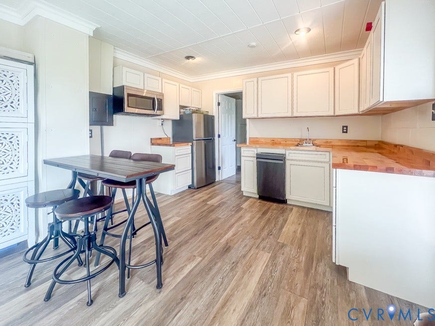 511 Riverview Court, Chester, VA 23836 Kitchen featuring wood-finish flooring, white cabinetry, integrated stainless steel microwave, and a paneled ceiling