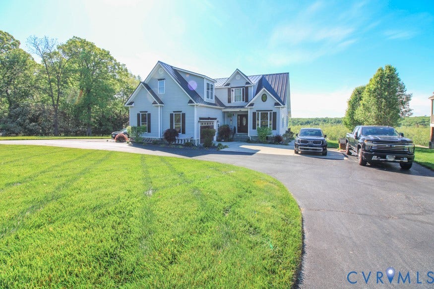 511 Riverview Court, Chester, VA 23836 Light blue siding exterior with dark shutters, gabled rooflines, and a metal roof accent