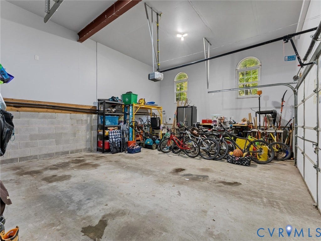 12100 English Ivy Lane, Glen Allen, VA 23059 Garage space featuring high ceilings, exposed structural steel beam, concrete flooring, and arched windows