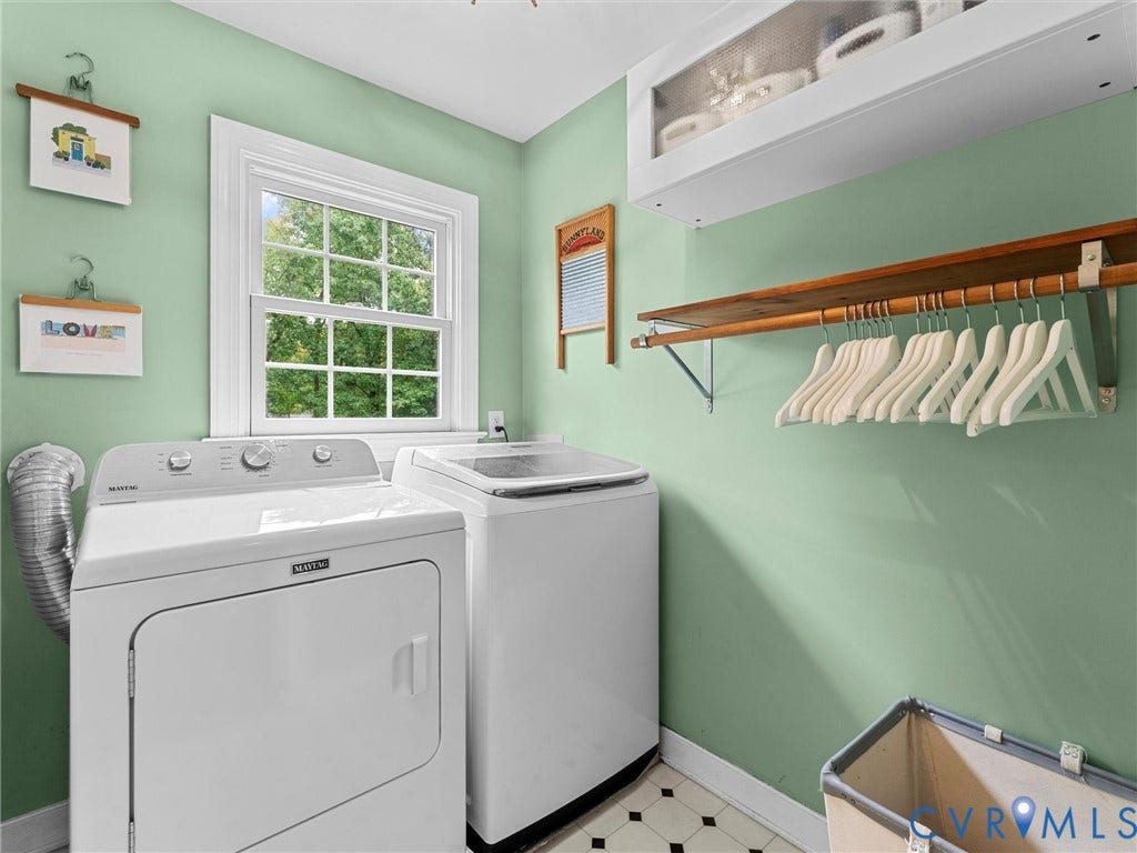 12100 English Ivy Lane, Glen Allen, VA 23059 Laundry space featuring a single-hung window, built-in upper cabinet with glass-panel doors, and wall-mounted wooden shelving with a metal hanging rod
