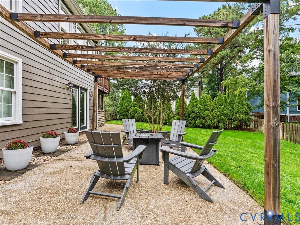 12100 English Ivy Lane, Glen Allen, VA 23059 Concrete patio featuring a timber-framed pergola, horizontal lap siding, and a fenced backyard with mature landscaping