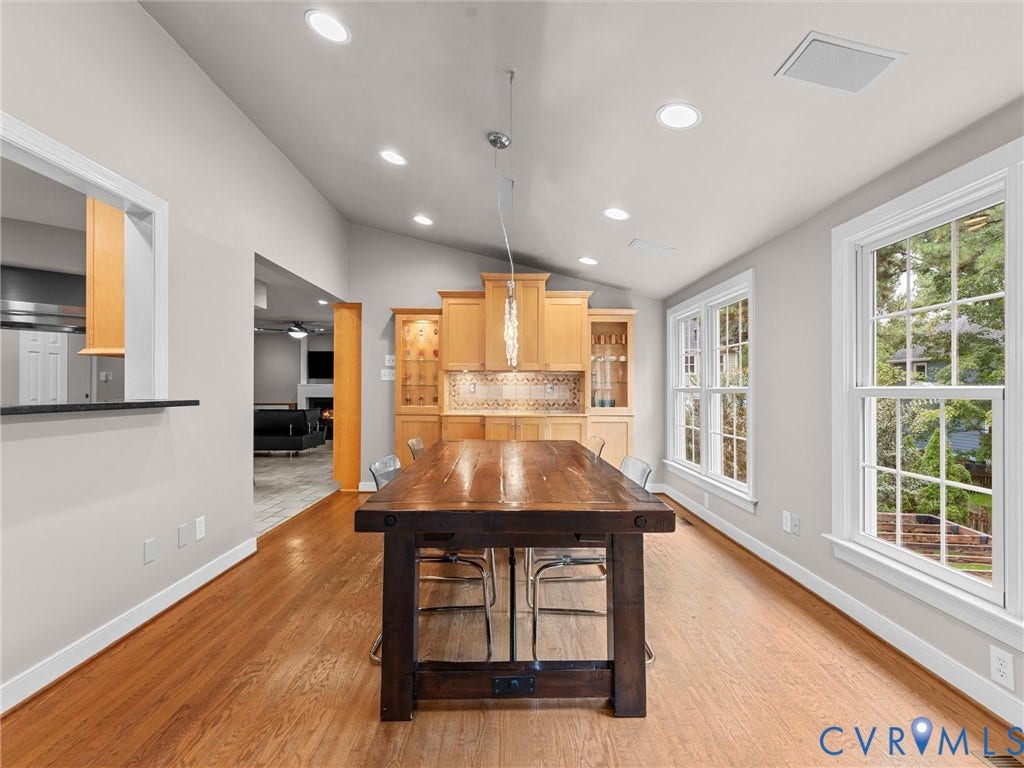 12100 English Ivy Lane, Glen Allen, VA 23059 Dining room featuring wood-finish flooring, vaulted ceilings with recessed lighting, built-in cabinetry with glass-front accents, and multi-pane windows