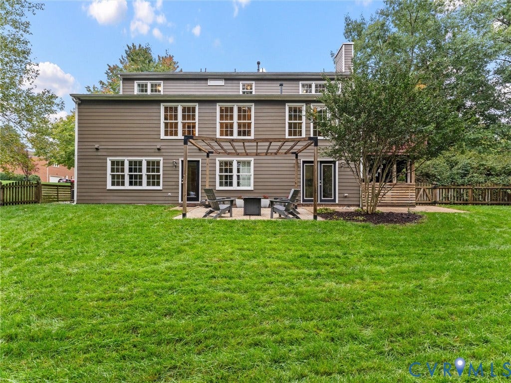 12100 English Ivy Lane, Glen Allen, VA 23059 Rear exterior featuring horizontal lap siding, a paved patio with a wooden pergola, expansive lawn, and fenced perimeter