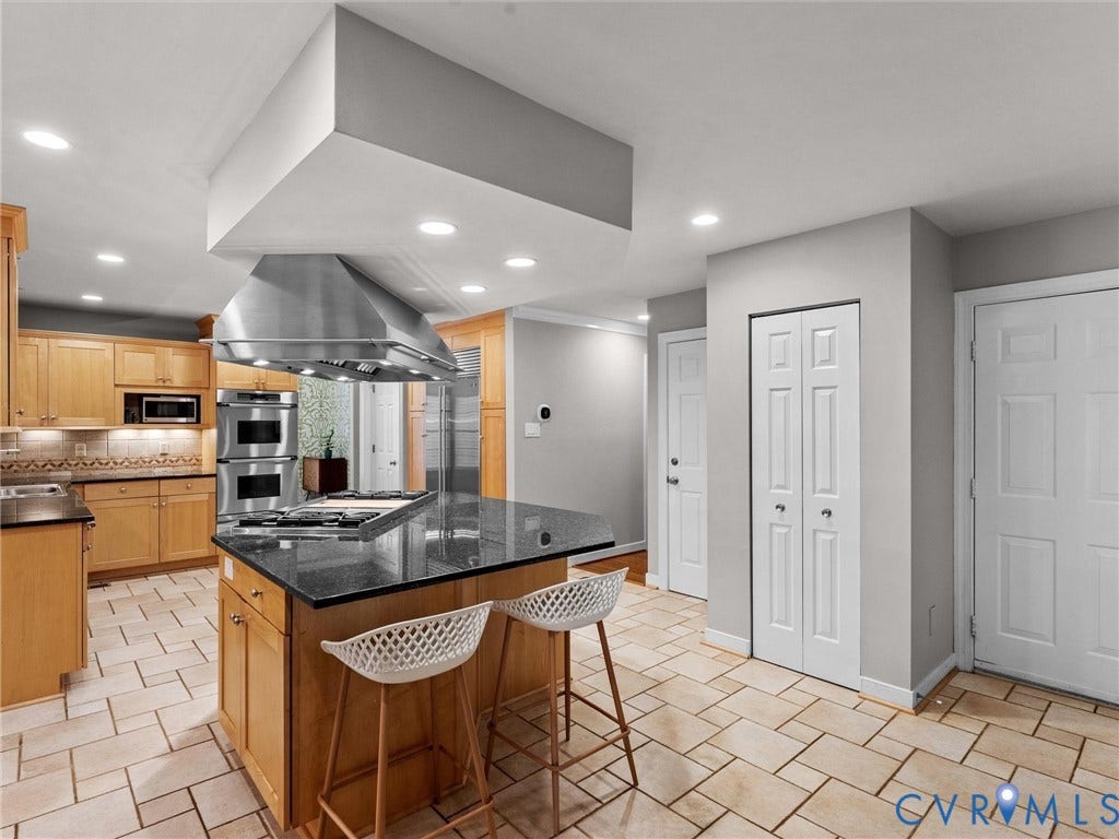 12100 English Ivy Lane, Glen Allen, VA 23059 Kitchen featuring wood cabinetry, dark stone countertops, stainless steel dual wall ovens, an oversized metal range hood, and tile flooring