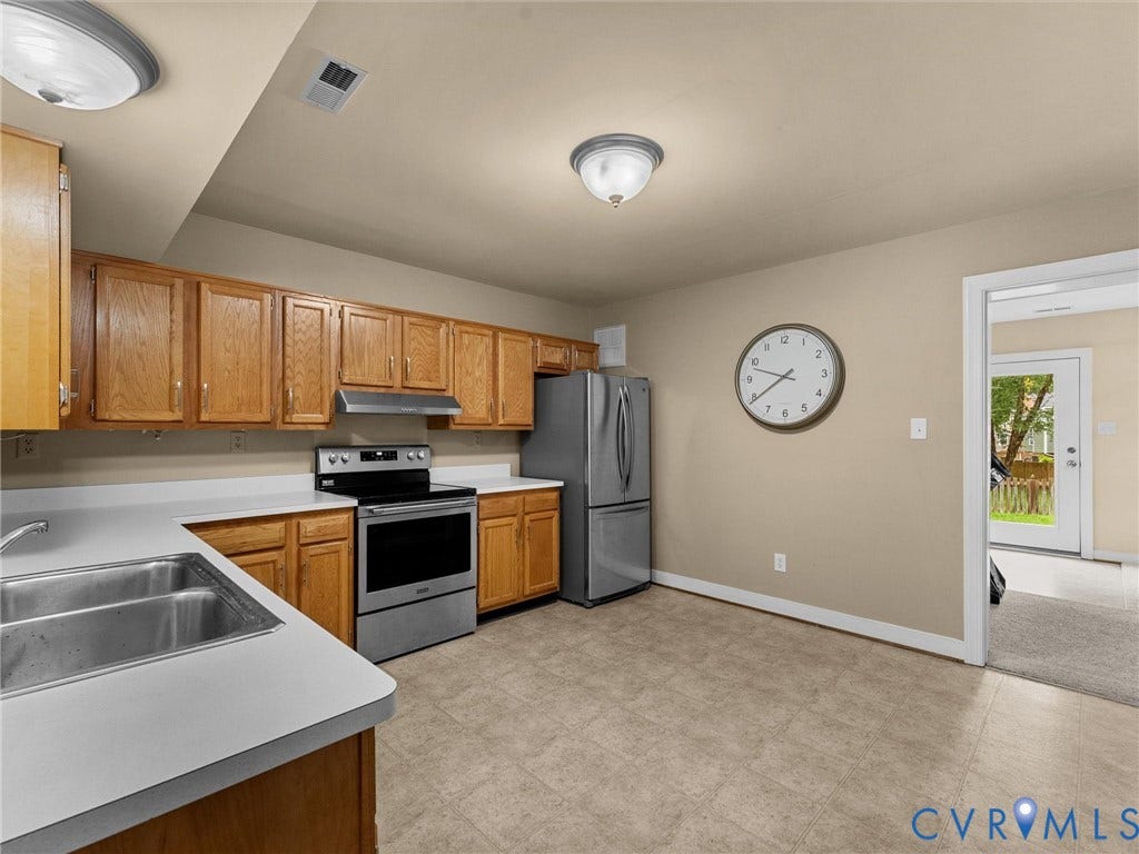 12100 English Ivy Lane, Glen Allen, VA 23059 Kitchen featuring wood cabinetry, stainless steel appliances, dual-basin stainless steel sink, solid-surface countertops, and flush-mount lighting fixtures