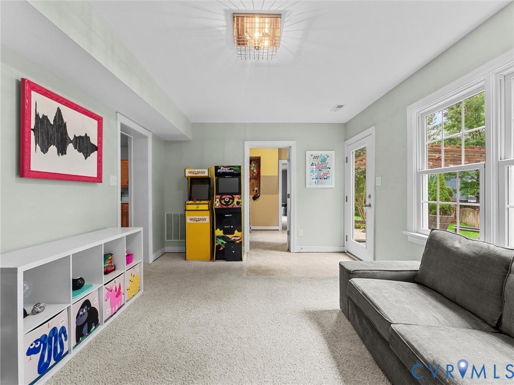 12100 English Ivy Lane, Glen Allen, VA 23059 Neutral-toned living space featuring wall-to-wall carpeting, a multi-pane grid window, glass-panel exterior door, and geometric flush-mount ceiling lighting