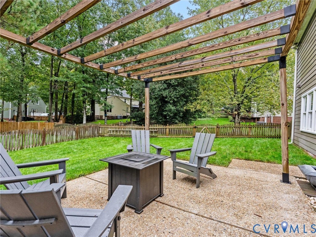 12100 English Ivy Lane, Glen Allen, VA 23059 Rear outdoor living area featuring a concrete patio, wood-beam pergola, and wood picket fencing