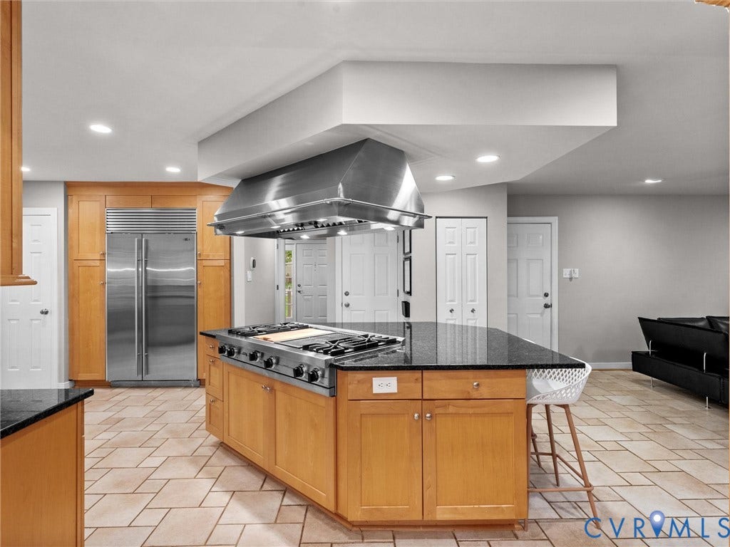 12100 English Ivy Lane, Glen Allen, VA 23059 Kitchen featuring an oversized central island with a stone countertop, professional-grade gas cooktop, stainless steel range hood, built-in panel-ready refrigerator, and tile flooring