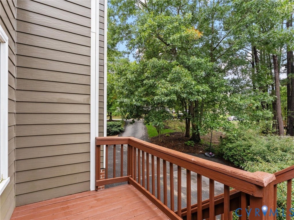 12100 English Ivy Lane, Glen Allen, VA 23059 Exterior deck featuring horizontal lap siding, wood-finish decking, and wood railing, overlooking mature trees and greenery