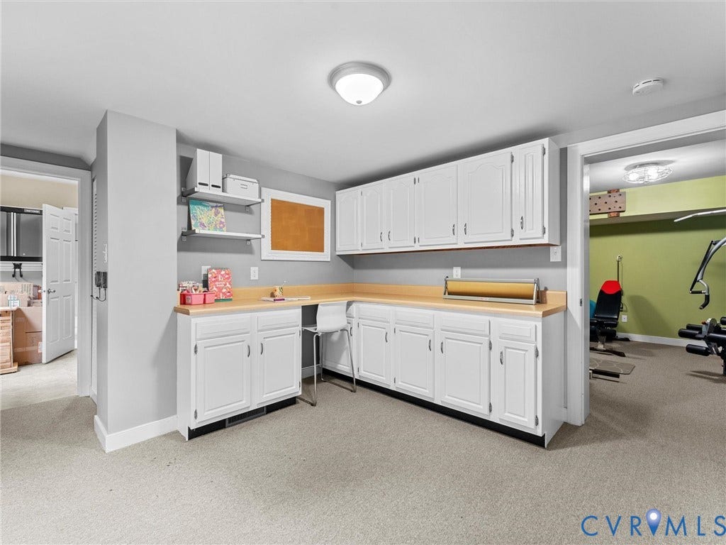 12100 English Ivy Lane, Glen Allen, VA 23059 L-shaped built-in workstation featuring white cabinetry, wood-surface countertops, wall-mounted shelving, and recessed ceiling lighting