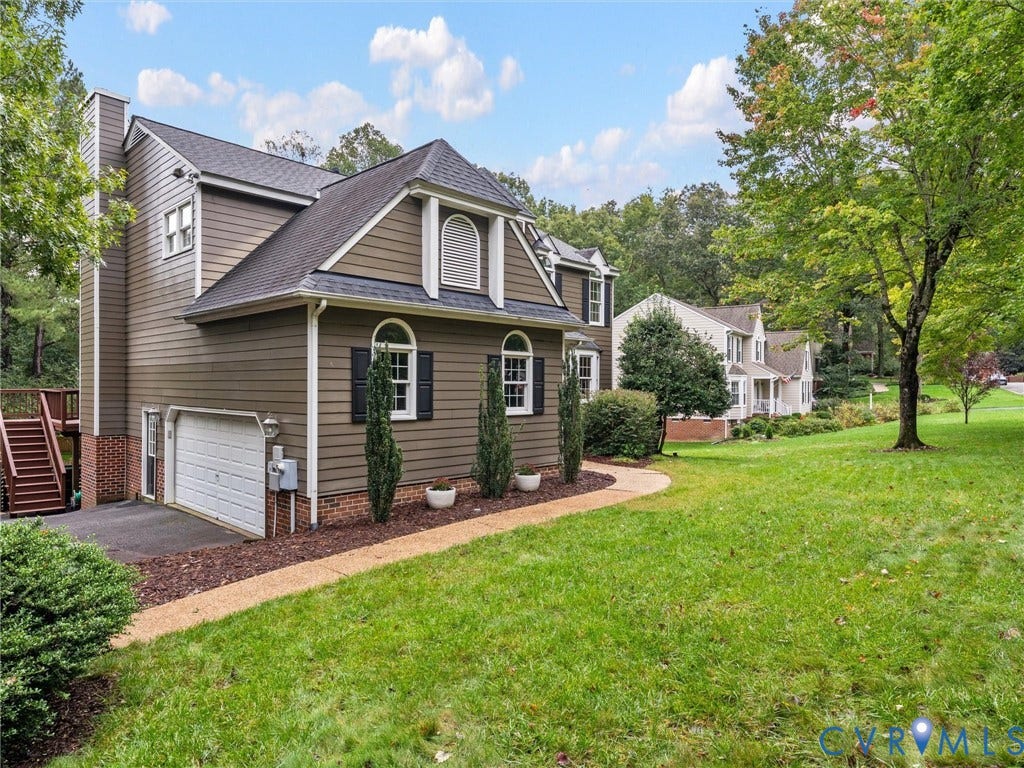 12100 English Ivy Lane, Glen Allen, VA 23059 Exterior featuring lap siding, brick foundation detailing, arched window accents, attached garage, and exterior wood deck