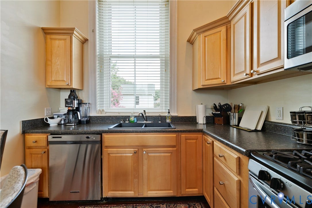 2021 North Avenue, Richmond, VA 23222 Kitchen featuring wood cabinetry, stainless steel dishwasher, double basin sink, and ample counter space