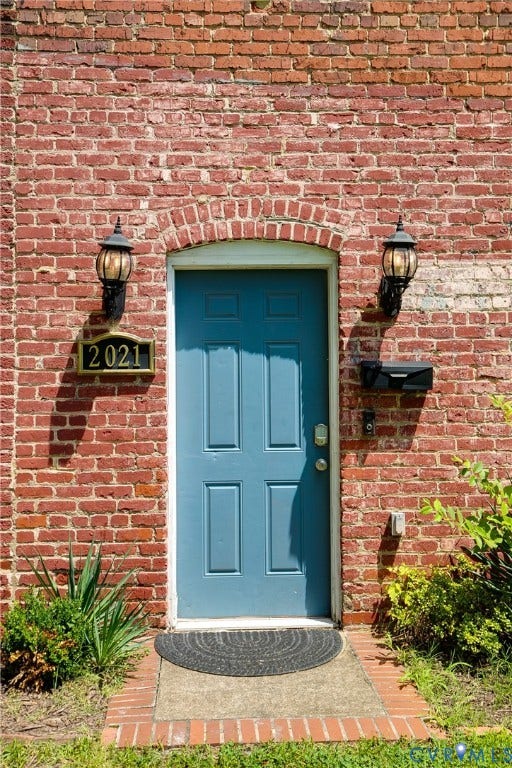 2021 North Avenue, Richmond, VA 23222 Brick exterior featuring an arched entryway and a panel door