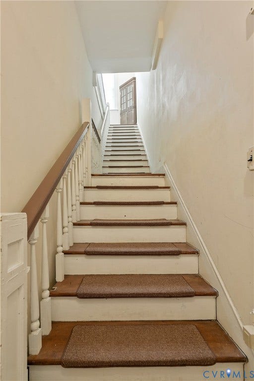 2021 North Avenue, Richmond, VA 23222 Staircase with wood-finish treads, white risers, and a classic wood handrail