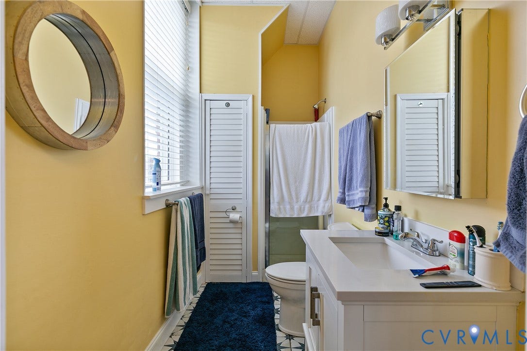 2021 North Avenue, Richmond, VA 23222 White vanity with integrated sink, chrome-finish faucet, and a wall-mounted medicine cabinet