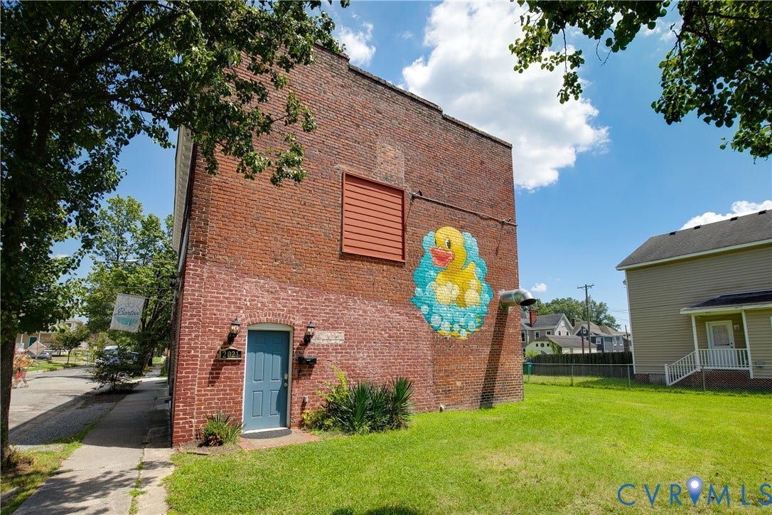 2021 North Avenue, Richmond, VA 23222 Brick exterior with a vibrant mural, a blue entrance door, and exterior lighting fixtures