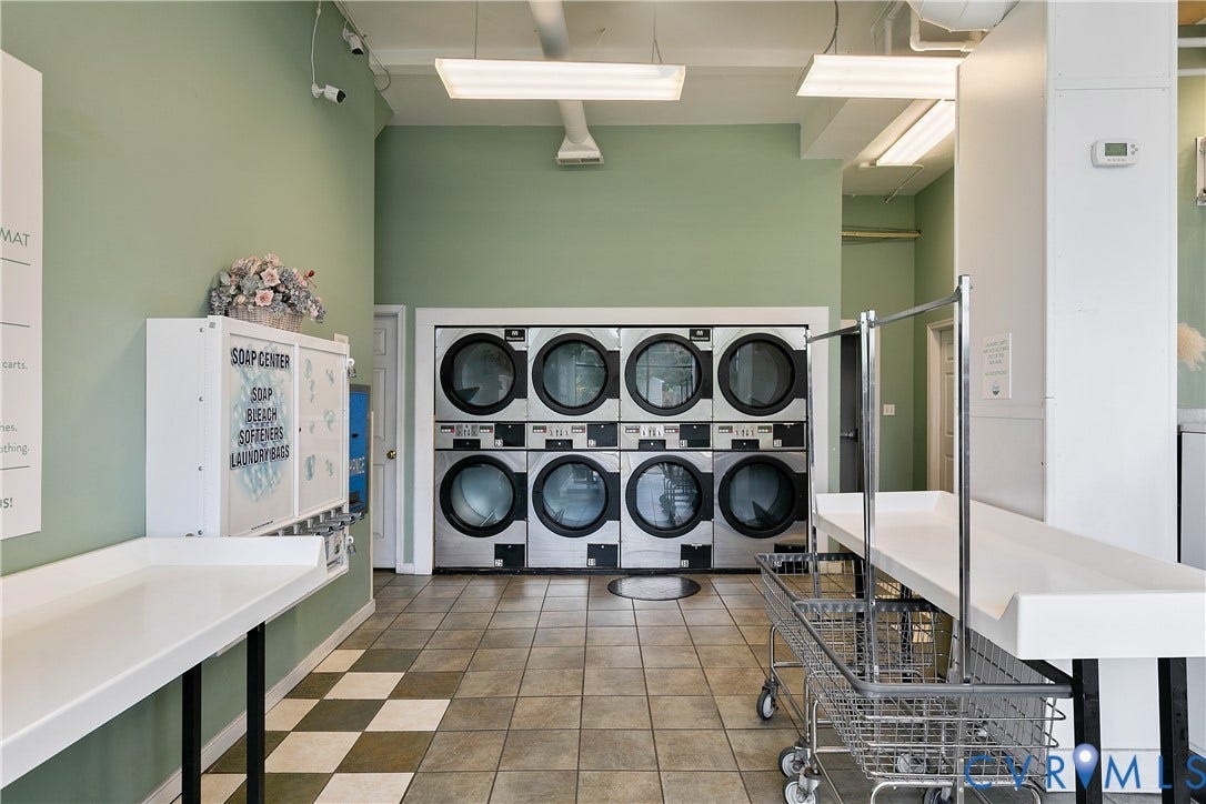 2021 North Avenue, Richmond, VA 23222 Dedicated laundry facility with multiple front-loading washers, durable tile flooring, white folding counters, and overhead fluorescent lighting