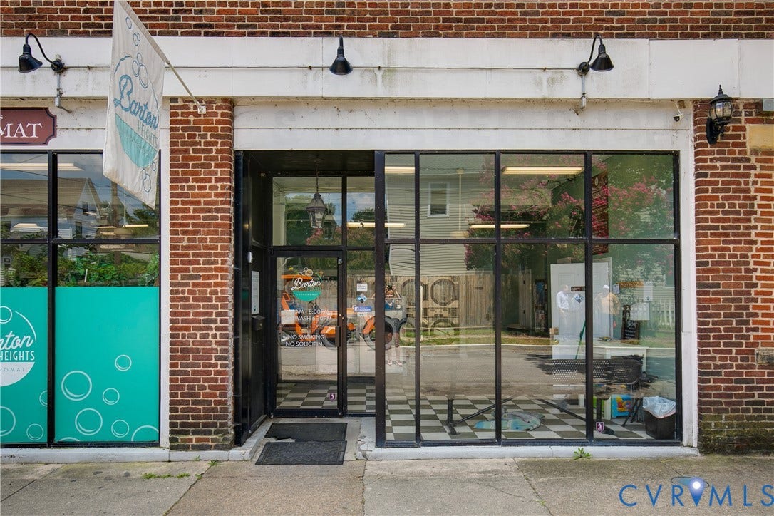 2021 North Avenue, Richmond, VA 23222 Brick facade with a white trim band, large storefront windows, and a glass-paneled entry door