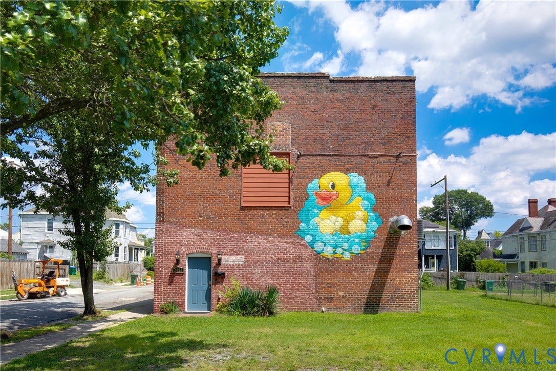 2021 North Avenue, Richmond, VA 23222 Brick exterior with a vibrant mural, blue entry door, and a grass area