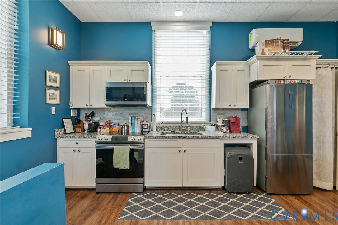 2021 North Avenue, Richmond, VA 23222 White cabinetry, stainless steel appliances, wood-finish flooring, stone-finish countertops, and a tile backsplash