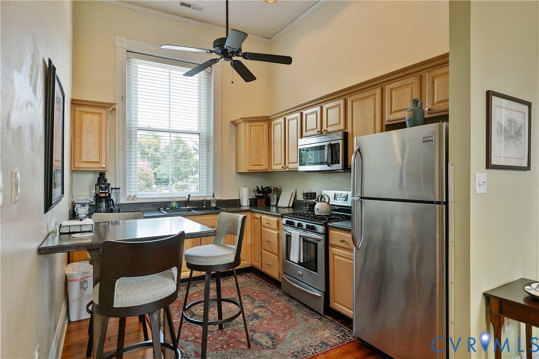 2021 North Avenue, Richmond, VA 23222 Kitchen featuring wood cabinetry, stainless steel appliances, a corner sink with a large window, and a ceiling fan