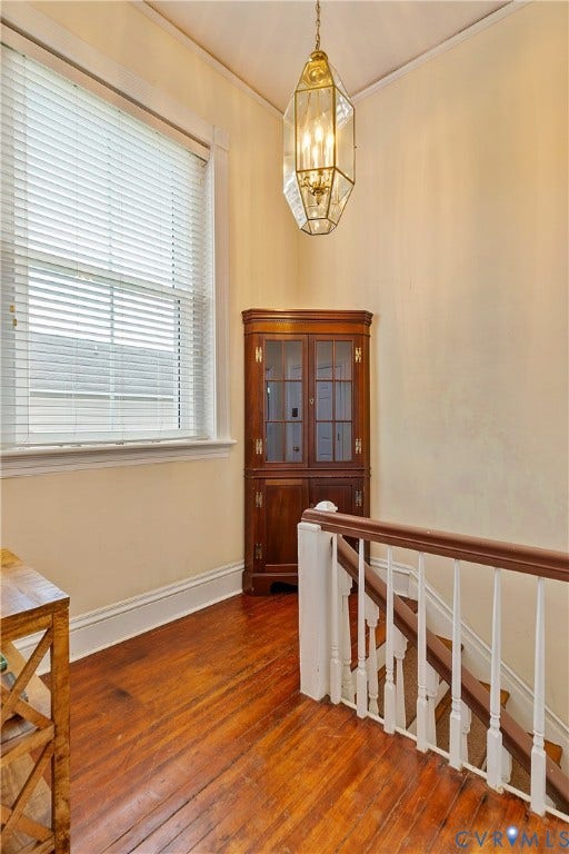 2021 North Avenue, Richmond, VA 23222 Rich wood-finish flooring, white painted baseboards, and a detailed staircase with white balusters