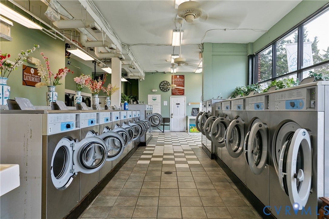 2021 North Avenue, Richmond, VA 23222 Commercial laundry facility featuring multiple front-load washing machines, ceiling fans, large exterior windows, and tiled flooring