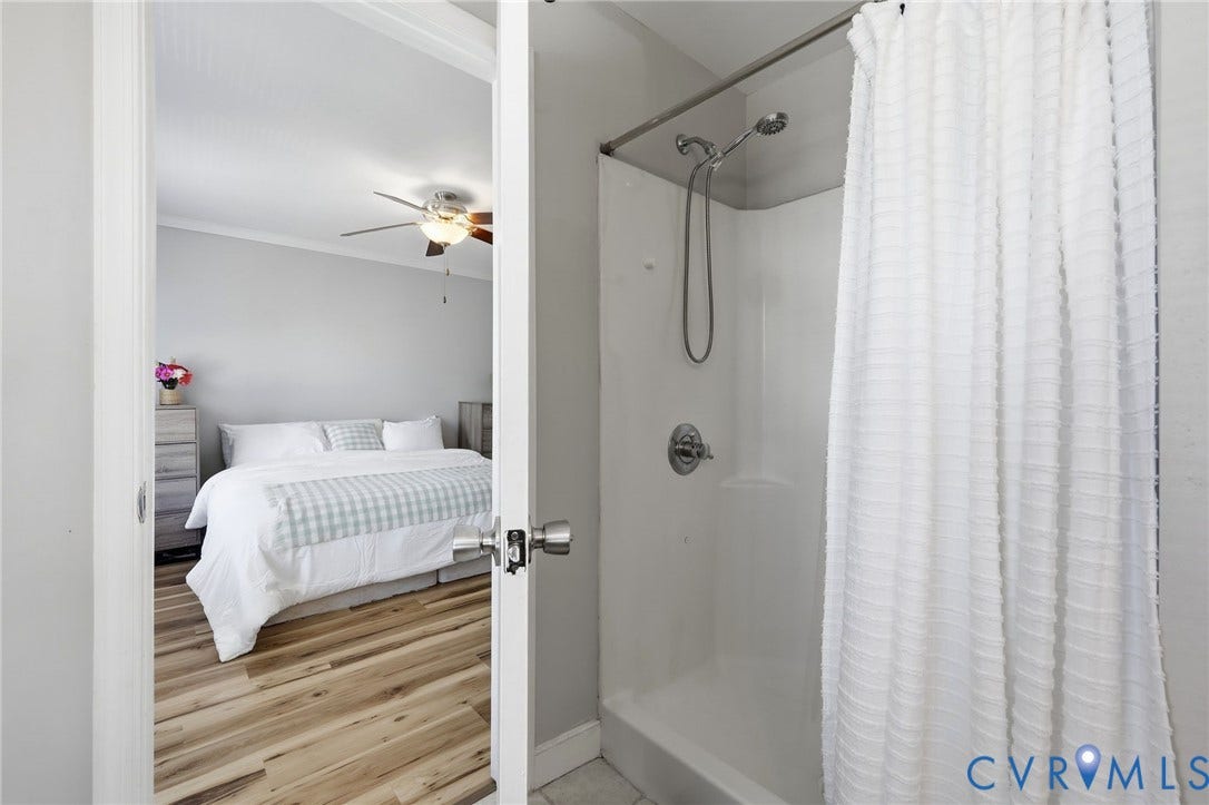 3015 M Street, Church Hill, Richmond, VA 23223 White shower stall with a curved shower rod and stainless steel fixtures