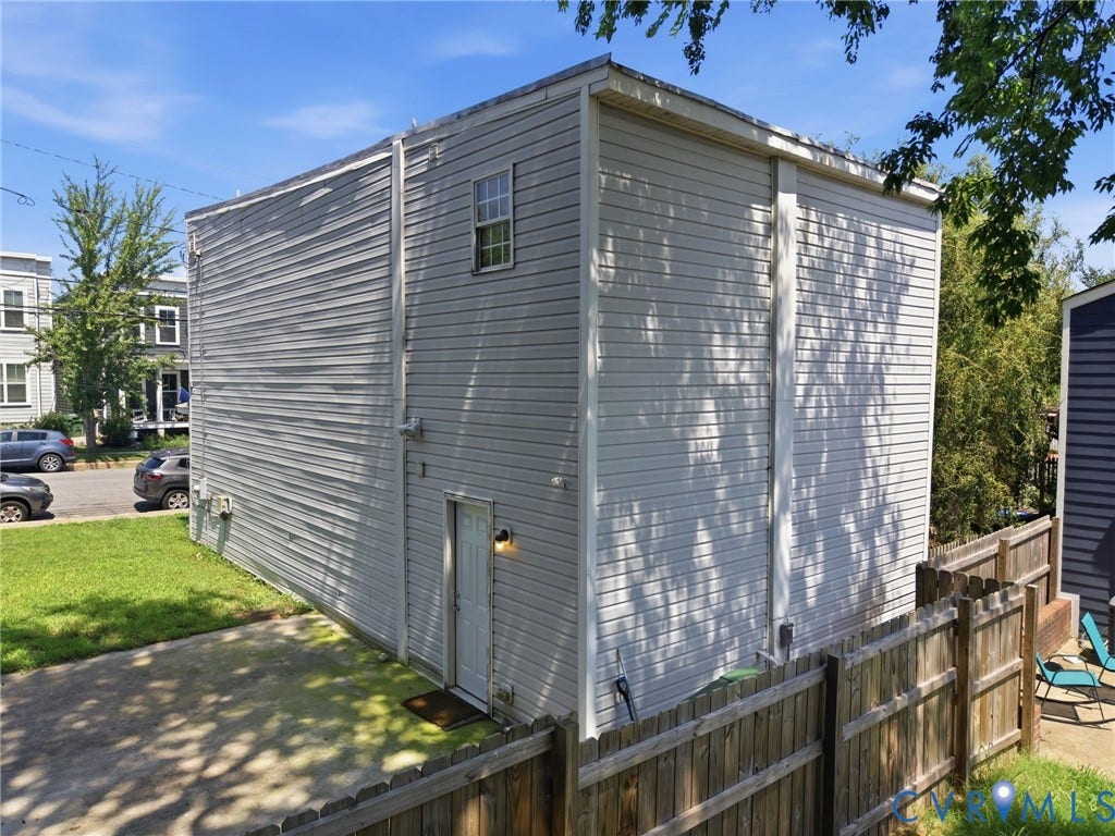 3015 M Street, Church Hill, Richmond, VA 23223 Exterior featuring light-colored siding, a wood fence, and a paved area
