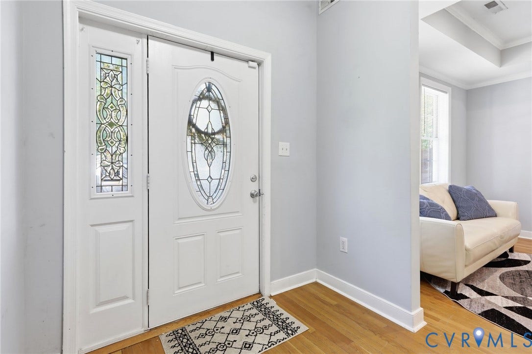 3015 M Street, Church Hill, Richmond, VA 23223 Entryway featuring wood-finish flooring, a white door with an oval stained-glass insert, and an adjacent sidelight with stained glass