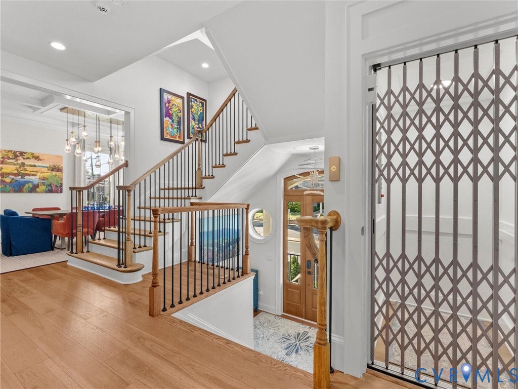 511 Libbie Avenue, #A, The Row At Westhampton, Richmond, VA 23226 Hardwood flooring throughout, a multi-level staircase with wood and iron railings, recessed lighting, and a private elevator